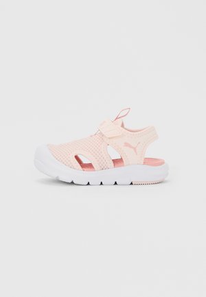 Light pink children's athletic sandal with mesh upper, adjustable strap, cushioned sole, and Puma logo on side.