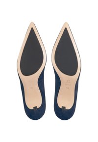 Paire de chaussures habillées en daim bleu marine à bout pointu, vues par la semelle, avec des semelles beige et des patins antidérapants noirs.