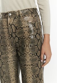 Slangenhuidpatroon broeken in tinten beige en zwart, met een glanzende textuur en een klassieke vijf-pocket ontwerp, met een sluiting met een knoop aan de voorkant.