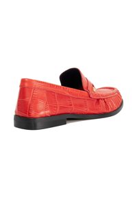 Red crocodile-embossed leather slip-on shoe with a flat black sole and stitched detailing along the upper edge, featuring a decorative gold accent.