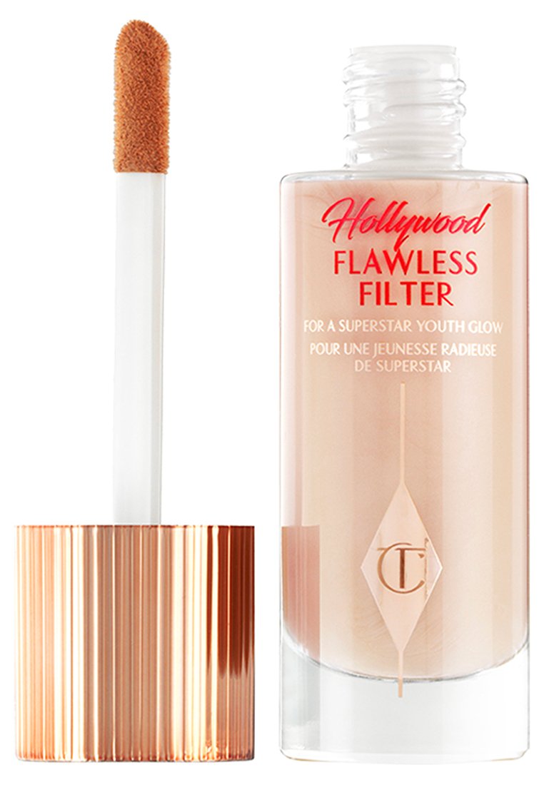 Bottiglia Flawless Filter con liquido trasparente, base rotonda in vetro e cappuccio coniche in oro rosa. Applicatore morbido con punta in peluche.