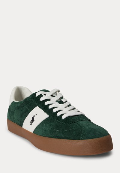 Πράσινο σουέντ αθλητικό παπούτσι με λευκά κορδόνια, λευκή πλευρική ρίγα με μαύρο λογότυπο παίκτη πόλο και καφέ λαστιχένια σόλα.