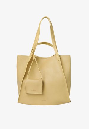 Duża beżowa torba typu tote z dwóch pasków na ramię i małą dopasowaną saszetką przymocowaną do jednego z pasków.