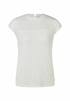 Blouse blanche à manches courtes en dentelle avec motifs floraux, encolure festonnée et détails semi-transparents sur les épaules et la partie supérieure de la poitrine.