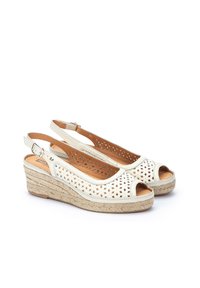 Sandalias de cuña blancas con punta abierta, patrones florales recortados, correa ajustable en el tobillo y detalle de yute trenzado en la base.
