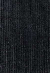 Nahaufnahme von schwarzem Cordstoff mit paralleler gerippter Textur und weichen, flauschigen Fasern.