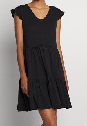 Schwarzes Baumwollkleid mit V-Ausschnitt, kurzen Kappenärmeln und einem abgestuften Rock mit gerafftem Stoff. Glatte Textur und lässige Silhouette.