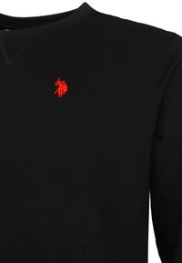 Čierna mikina s okrúhlym výstrihom a malým červeným vyšitým logom polo hráča na ľavej hrudi.