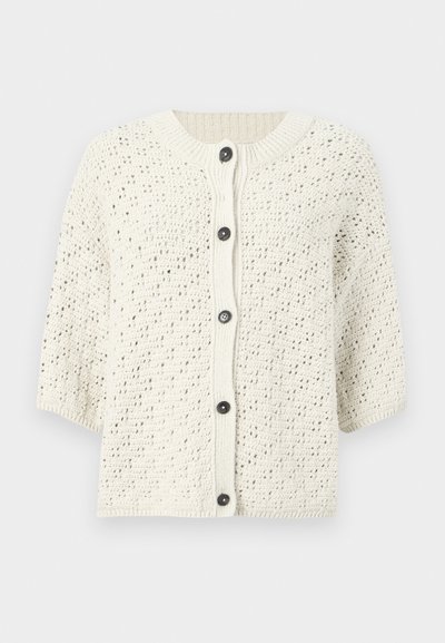 Πλεκτή ζακέτα σε κρεμ χρώμα με υφασμένη υφή, κοντά μανίκια και πέντε μαύρα κουμπιά μπροστά, με ριμπ γιακά.