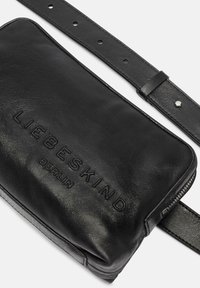 Borsa a tracolla in pelle nera con logo impresso "LIEBESKIND BERLIN", chiusura con zip e tracolla regolabile. Texture liscia, design minimal.