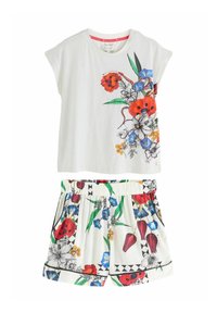 Twee-delige outfit met een witte top met korte mouwen en een kleurrijke bloemenprint, en bijpassende shorts met elastische tailleband en geometrische accenten.
