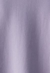 Tejido de lavanda con una textura suave y lisa, superficie ligeramente brillante. El color es uniforme con sutiles variaciones en la luz.