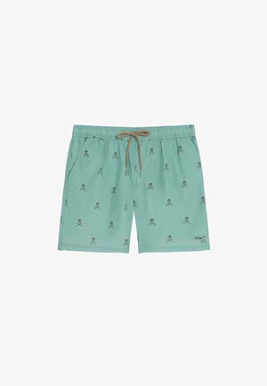 Bañador corto de color verde azulado claro con estampado negro de calaveras y huesos cruzados, cordón beige y bolsillos laterales.