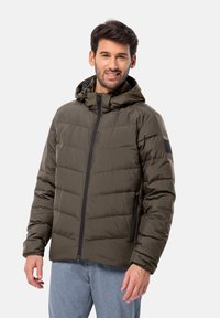 Giubbotto puffer verde oliva con cappuccio, dotato di chiusura con zip, tasche laterali e design trapuntato. Realizzato in un materiale leggero e testurizzato.