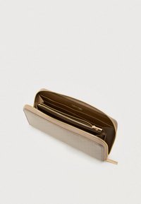 Μπεζ πορτοφόλι Calvin Klein με υφή καπιτονέ, χρυσαφί φερμουάρ και πολλαπλές θήκες σε αντίθετο καφέ εσωτερικό.