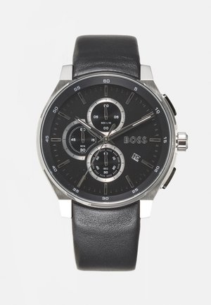 Czarny skórzany zegarek na pasku z okrągłą stalową kopertą, czarną tarczą, trzema sub-tarczami i wyświetlaczem daty na godzinie 6. Srebrne wskaźniki godzinowe.