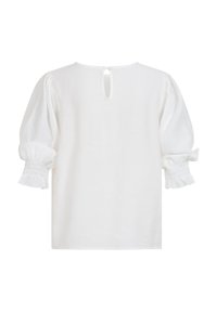 Blouse blanche avec manches froncées et bouffantes se terminant par des poignets à volants et une petite fente avec bouton au dos du col.