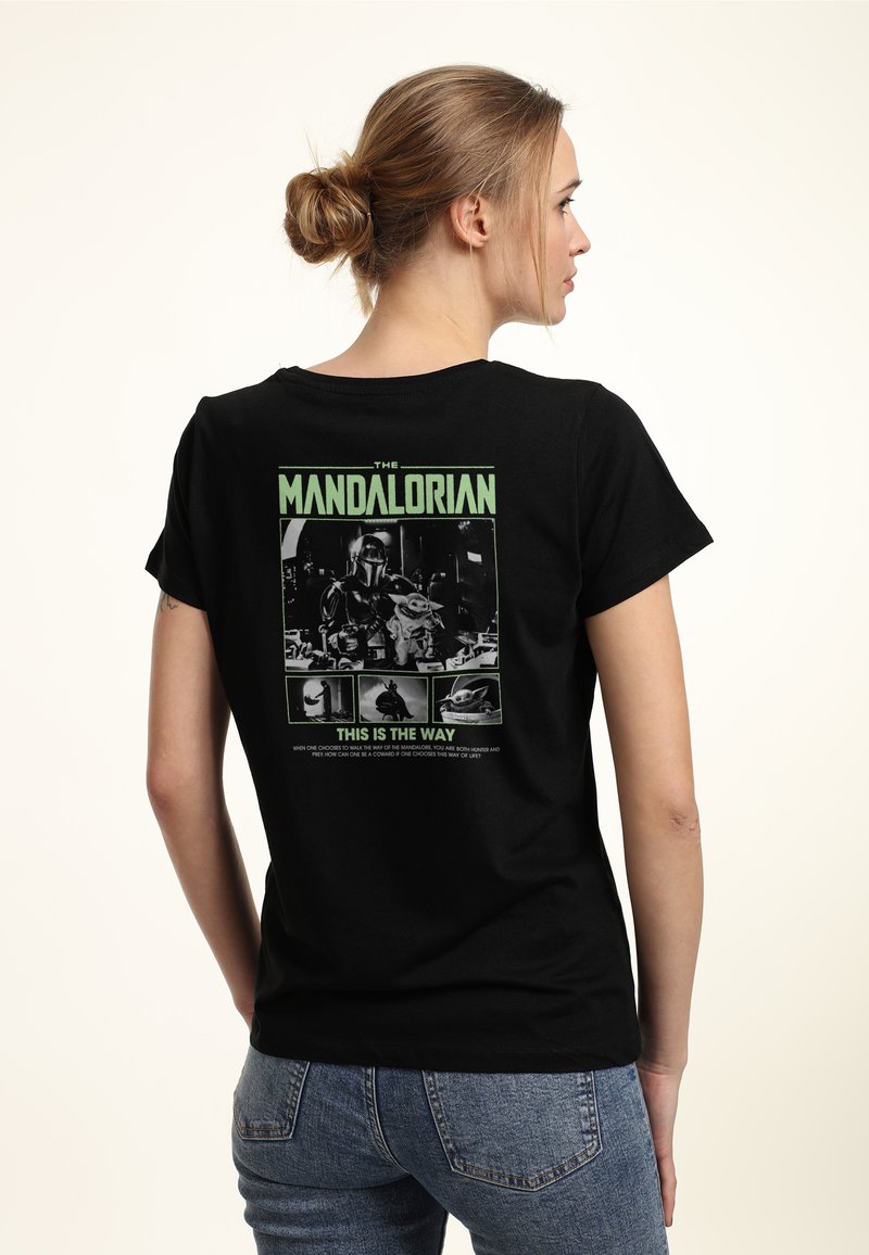 Svart bomull t-shirt med en färgglad grafisk tryck på ryggen som föreställer karaktärer och text från "The Mandalorian." Korta ärmar.