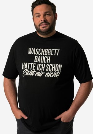 Camiseta negra de algodón con texto en blanco en negrita que presenta frases en alemán. Manga corta y corte relajado, con una ligera textura visible en la tela.