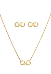 Collana a forma di infinito in tono dorato con orecchini coordinati, caratterizzata da linee sinuose e curve e una finitura lucida. Design semplice con una texture lucente.