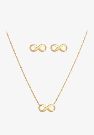 Gouden infinity-halsketting met bijpassende oorbellen, met gladde, gebogen lijnen en een gepolijste afwerking. Eenvoudig ontwerp met een glanzende textuur.