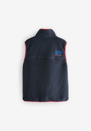 Tumši zils vilnas veste ar augstu apkakli, sarkanu apmali un "SUPERDRY" logotipu izšūtu zilā krāsā pa kreisi. Mīksta tekstūra un piedurkņu tr ūkums.
