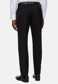 Črne krojene hlače z gladkim finišem, ki imajo naravno obliko nogavic, dve zadnji žepki in črn pas.