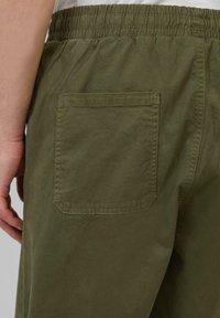 Khaki groene shorts met een elastische tailleband, voorzien van een enkele achterzak en een gladde, geweven stof.