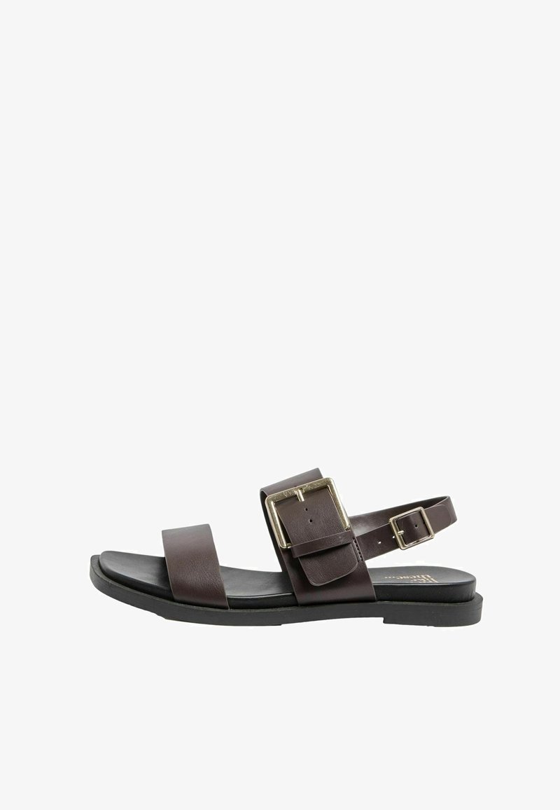 Sandalo in pelle marrone scuro con due cinturini con fibbia, suola piatta nera e design aperto sulla punta e sul tallone.