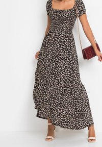 Černé květinové maxi šaty s krátkými rukávy a čtvercovým výstřihem. Obsahují malé bílé a růžové květy, texturovanou l�átku a splývavou sukni.