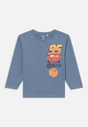 Kratki rukavi plavi majica dugih rukava od pamuka, s grafikom crvenog automobila, brojem "95" i "Rust-eze" logom u narančastoj i žutoj boji.