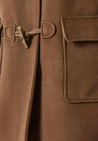 Brauner Wollfilzmantel mit glatter Textur, ausgestattet mit einem Knebelverschluss, einem gewebten Gürtel und aufgesetzten Taschen auf beiden Seiten.