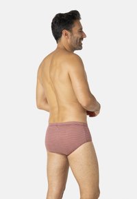 Slip de bain rouge à motifs en tissu lisse, avec une coupe ajustée et une ceinture élastique. Vue arrière montrant un motif géométrique.