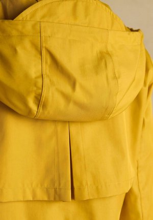 Żółta kurtka z kapturem, z plisowanym tyłem. Wykonana z gładkiego materiału z widocznymi szwami i zaokrąglonym kapturem.