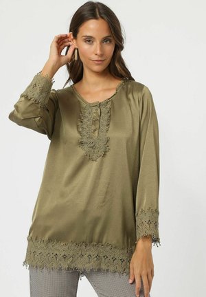 Blusa verde oliva con detallado encaje intrincado, mangas largas y escote redondo con detalles de botones en la parte delantera, en un tejido suave.