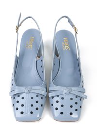 Jasnoniebieskie buty slingback z perforowanym wzorem, kwadratowym noskiem i detalem w postaci kokardy. Wykonane z błyszczącego materiału, z goldowym logo w środku.