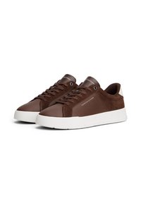 Low-top brown leather and suede sneakers with white soles, laces, and Tommy Hilfiger logo on side and tongue.