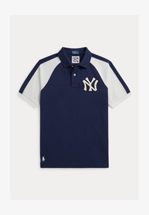 Tengerészkék és fehér rövid ujjú galléros póló New York Yankees logóval a mellkason és kis fehér Ralph Lauren emblémával az alsó szegélynél.