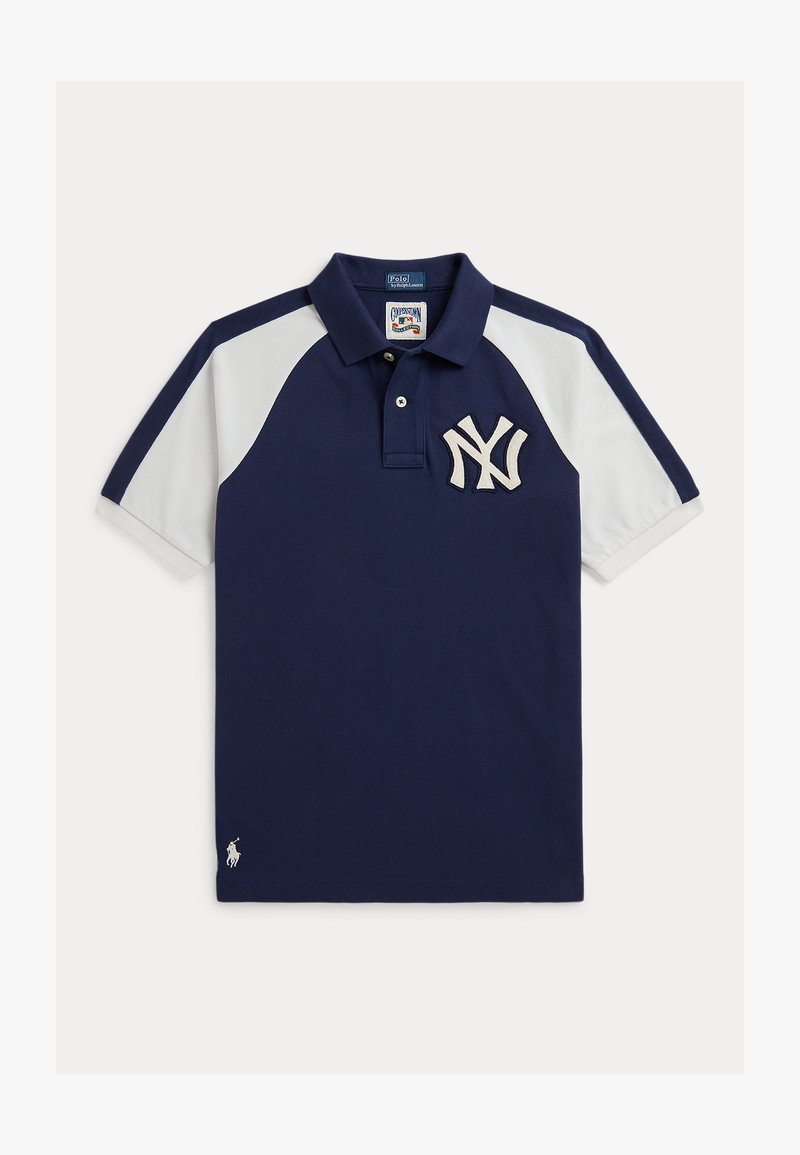Tumši zils un balts polo krekls ar īsām piedurknēm, ar Ņujorkas Jeņķu komandas logo uz krūtīm un nelielu baltu Ralph Lauren emblēmu pie apakšmala.