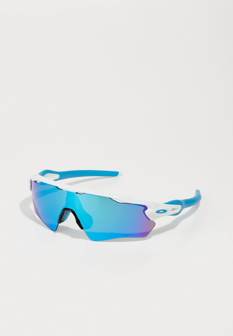 Sunglasses with a wraparound design, featuring a white frame and blue accents. The lenses have a gradient tint from blue to purple.