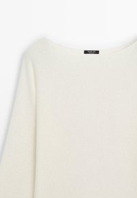 Cremfarbener Strickpullover mit langen Ärmeln und weitem Rundhalsausschnitt, ausgestattet mit einem kleinen Markenetikett im Kragen.