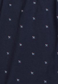 Granatowy materiał z małymi, kolorowymi haftowanymi wzorami strzałek w czerwonym, niebieskim i białym kolorze, tworzącymi jednolitą, teksturowaną powierzchnię.