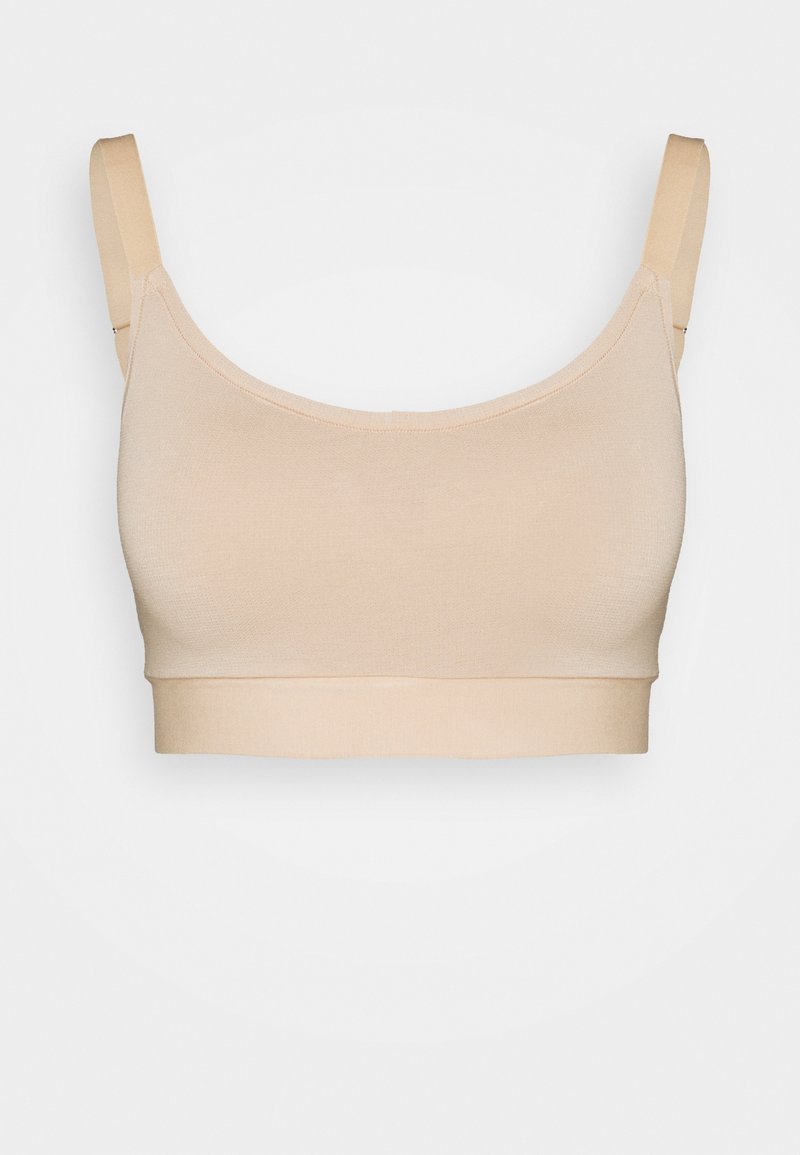 Beige Stretchstoff-Bralette mit verstellbaren Trägern, nahtlosem Design und breitem elastischem Band. Weiche Textur und glatte Oberfläche.