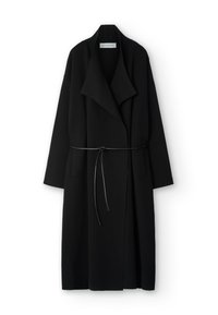 Musta pitkä takki, valmistettu rakenteellisesta kankaasta, jossa leveä kaulus, avoin edusta ja irrotettava vyötärölle solmittava vyö. Kaksi sivutaskua näkyvissä.