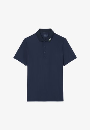 Polo náutico confeccionado en una tela suave, con un collar clásico, tapeta de tres botones y pequeño logo de cocodrilo verde en el cuello.