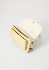 Carteira estruturada com um exterior em imitação de pele branca cremosa e um bolso frontal em palha tecida; inclui um fecho de pressão dourado.