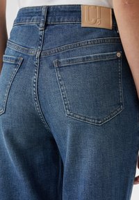 Jeans aus Denim in einem mittleren Blauton, mit einer hohen Taille, Gesäßtaschen und einem glatten Lederlabel am Bund.