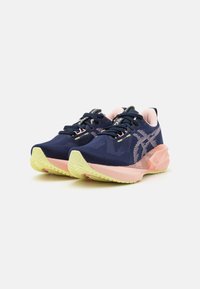 Baskets de sport navy avec des accents roses et une tige texturée. Présentent une semelle extérieure épaisse de couleur jaune clair et un design textile à motif.