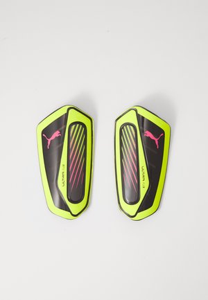 Schwarze und neongelbe Fußballschienbeinschoner mit glatter Textur, versehen mit pinken Linien und einem Puma-Logo. Jeder Schoner hat eine aerodynamische Form.