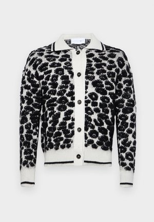 Cárdigan de estampado de leopardo en blanco y negro con un patrón texturizado, cuenta con un cierre de botones en la parte delantera, puños acanalados y un cuello en contraste.